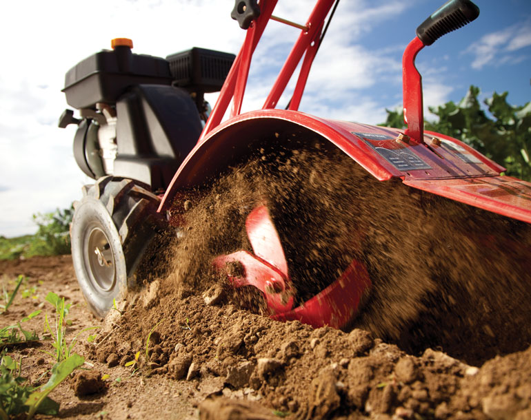 Troy-Bilt walk-behind tiller creating finely turned garden soil