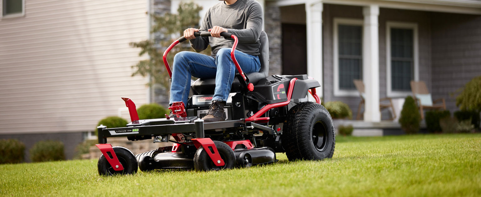 man using new electric zero turn mower mowing his grass