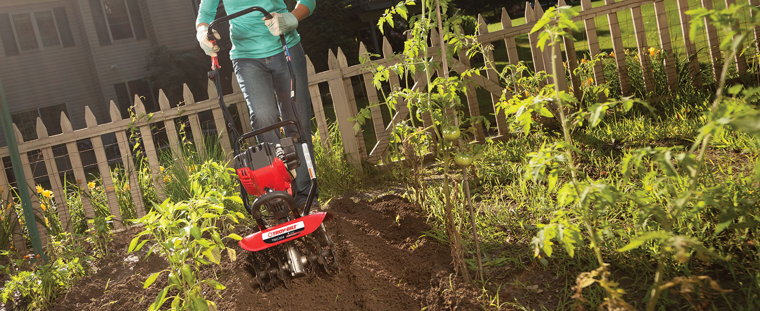 woman tilling her backyard garden