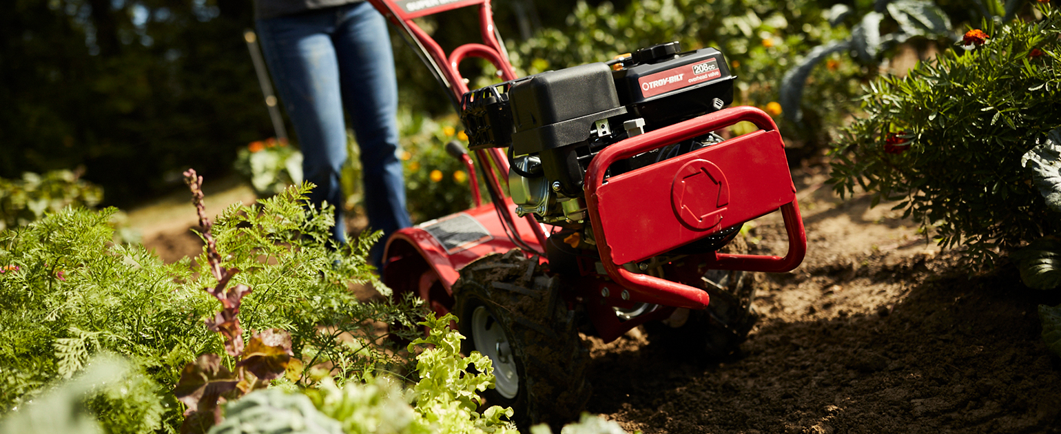 woman using tiller to till soil