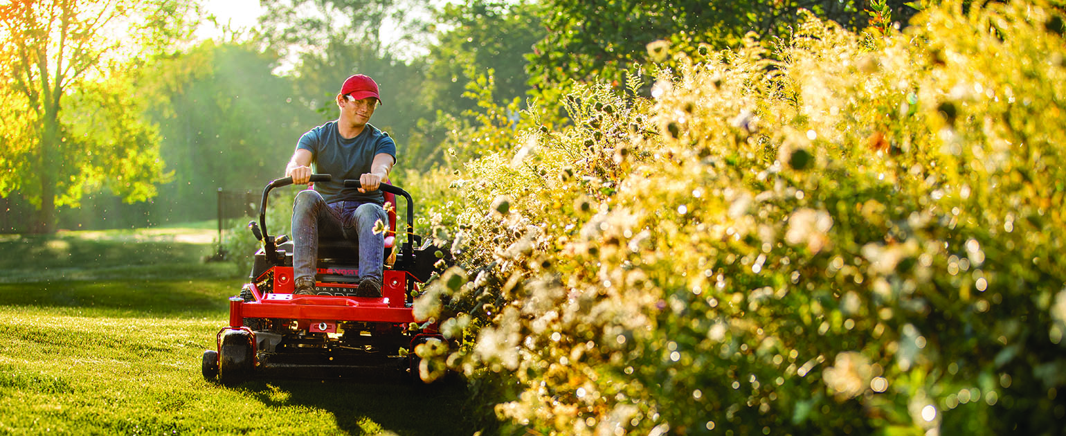 person cutting grass with a troy bilt z42 mustang zero-turn mower