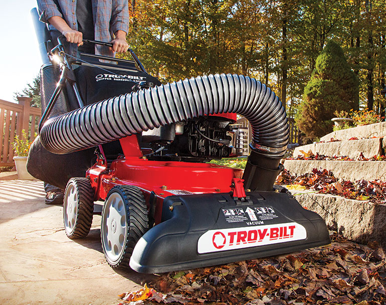 Man using Troy-Bilt chipper shredder tree mulcher vacuum extension to remove leaves