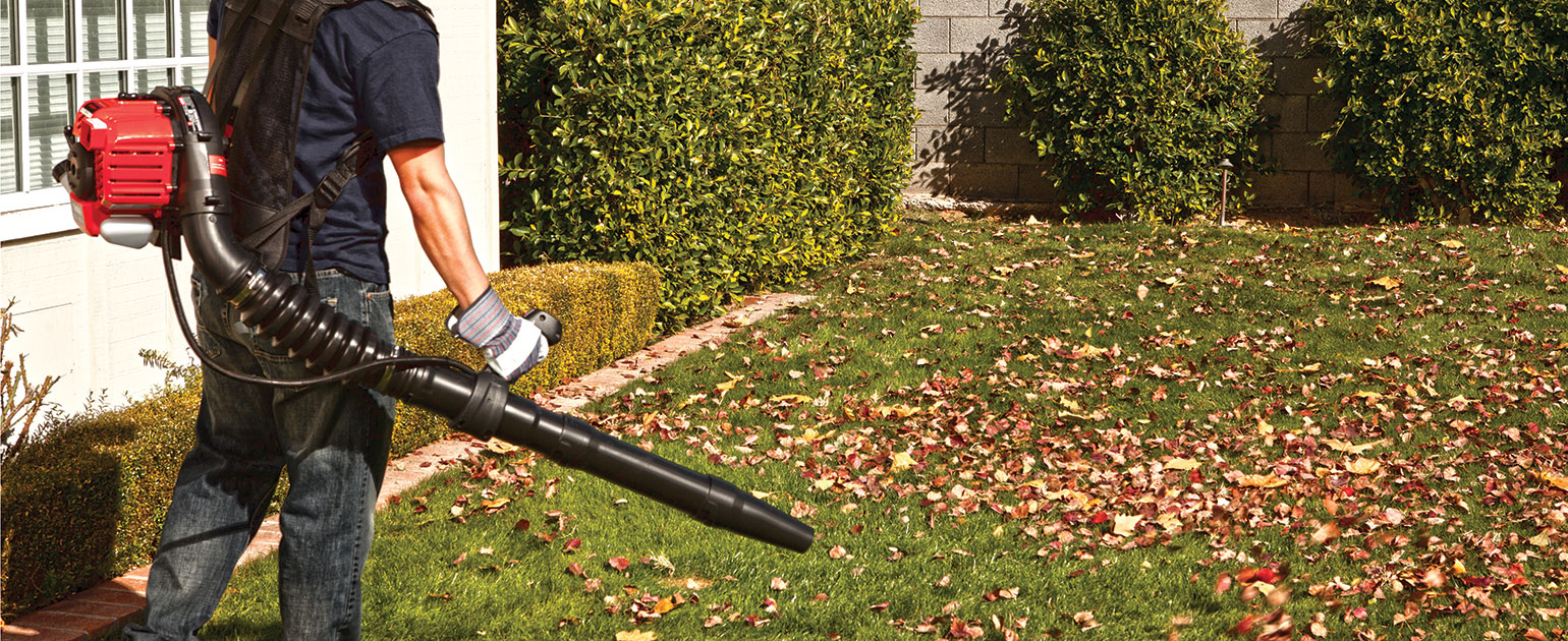 man using Troy-Bilt backpack leaf blower on lawn