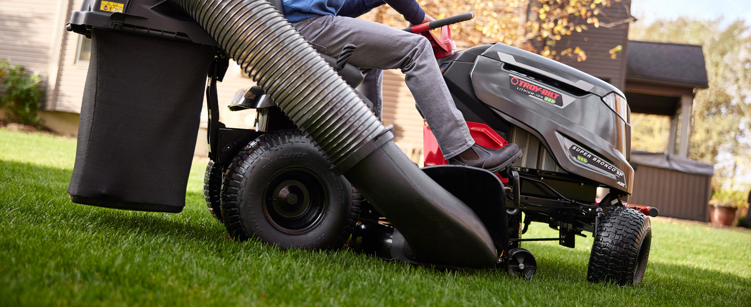 close up of woman cutting lawn with a riding mower