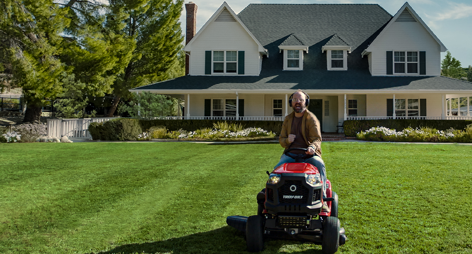 man on riding mower listening to music