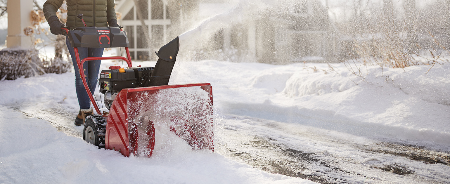 person plowing driveway with two stage snow blower