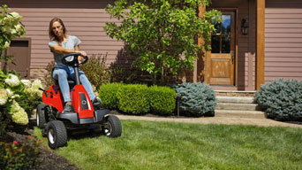 woman on a zero-turn lawn mower