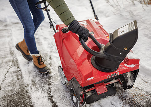 woman adjusting the chute position on a single-stage snow blower