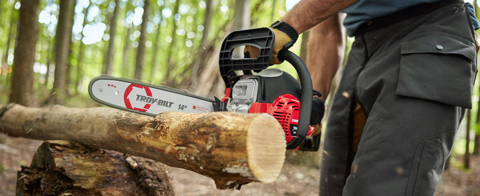 close up of person cutting a log with a chainsaw