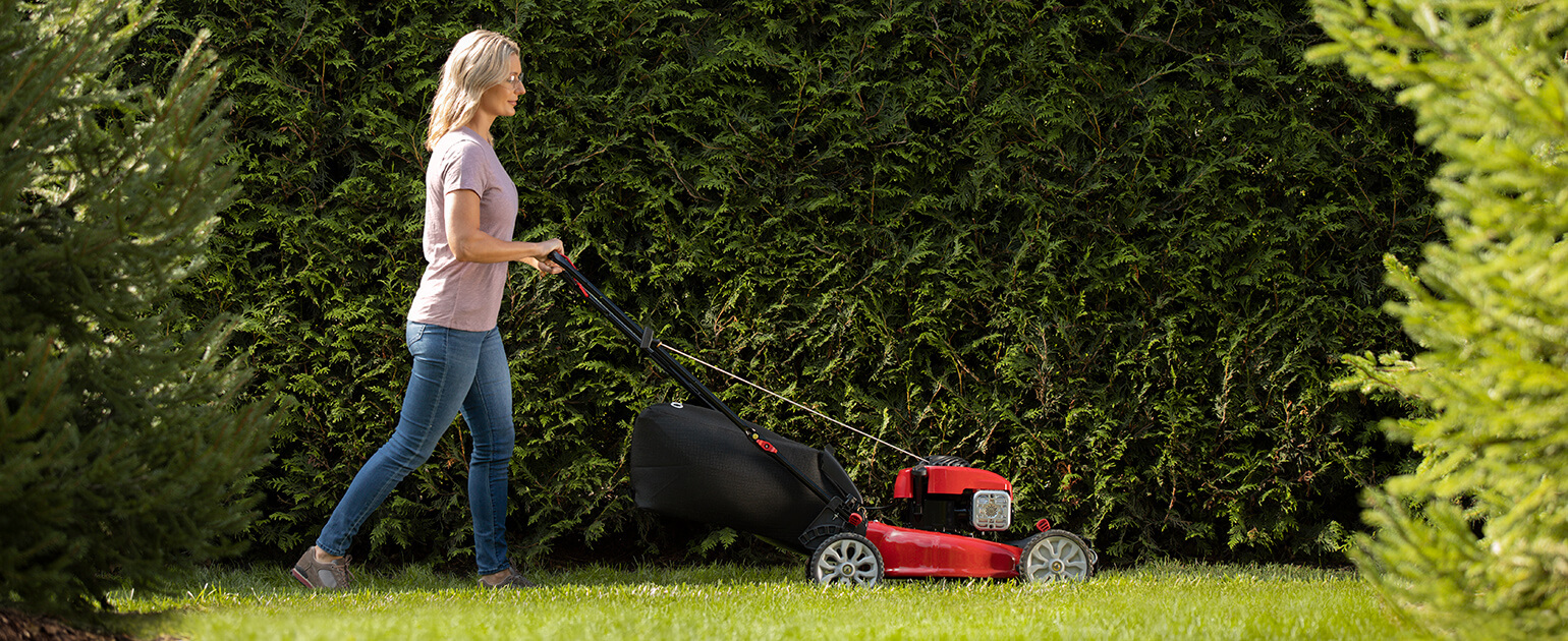 woman pushing walk behind mower