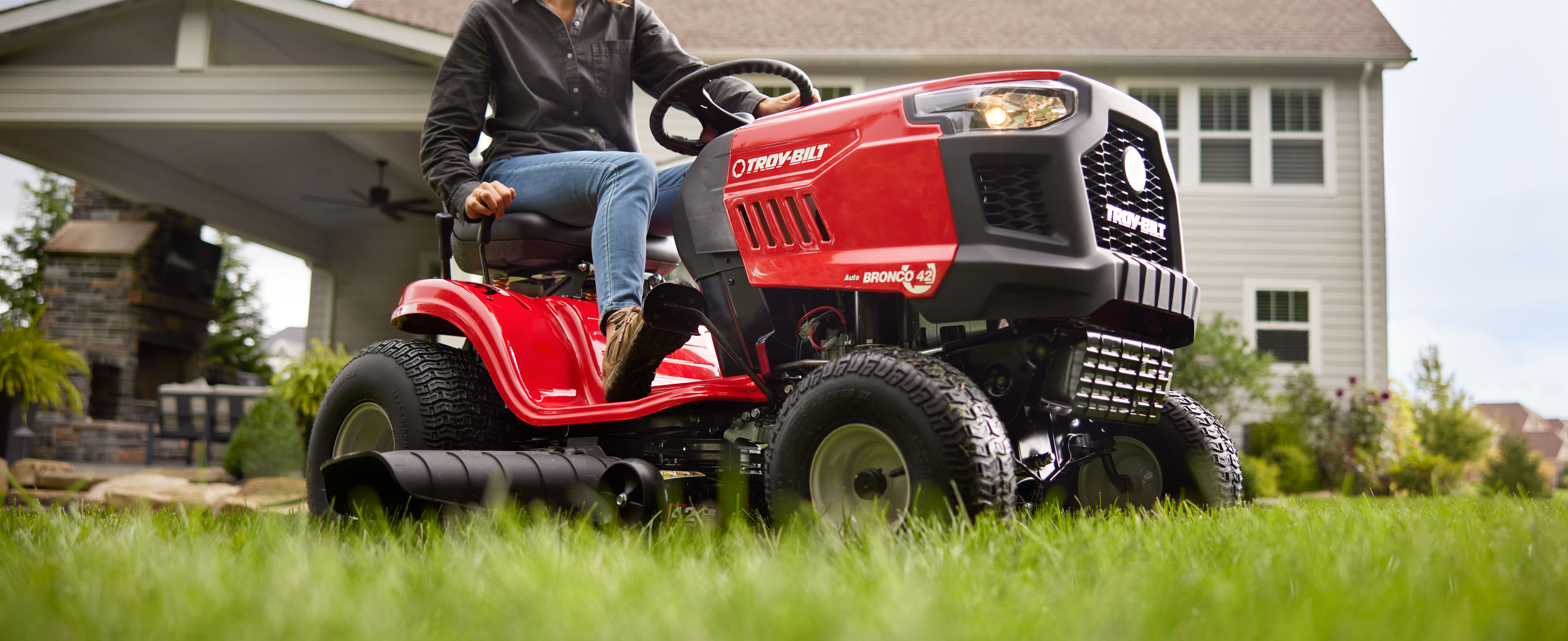 person cutting grass with a troy bilt riding lawn mower