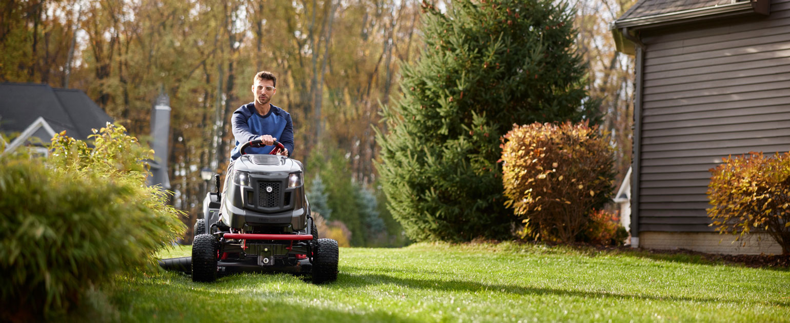 man riding new electric riding mower cutting his grass