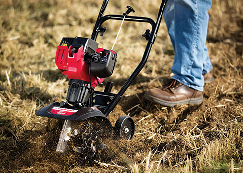 Man cultivating soil with Troy-Bilt garden cultivator