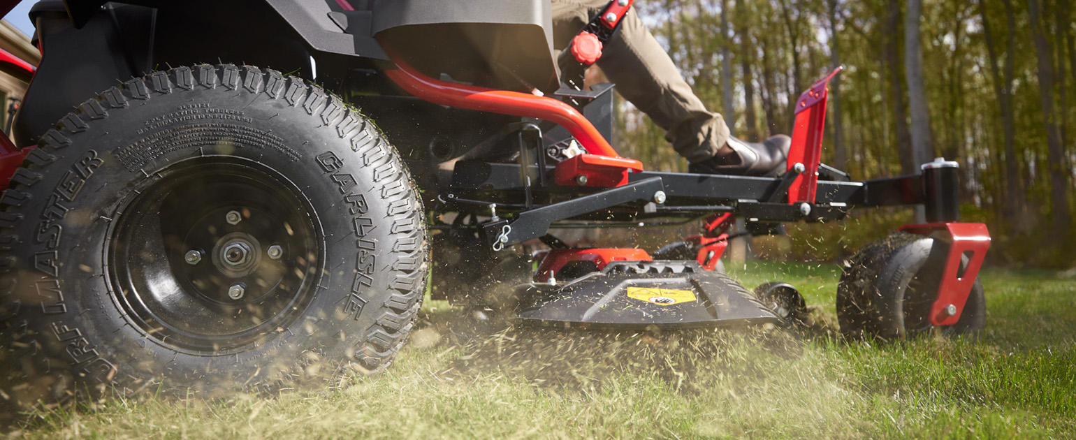 new troy-bilt electric riding mowers next to each other in front of a house