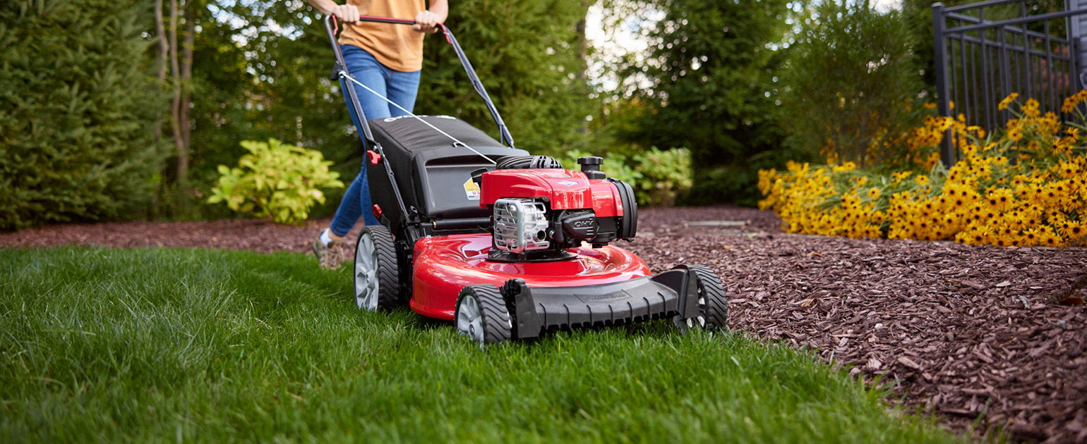 woman pushing walk behind mower