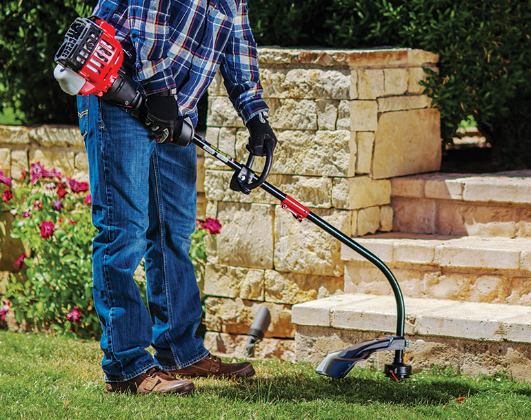 man trimmer grass by the bottom of stone steps