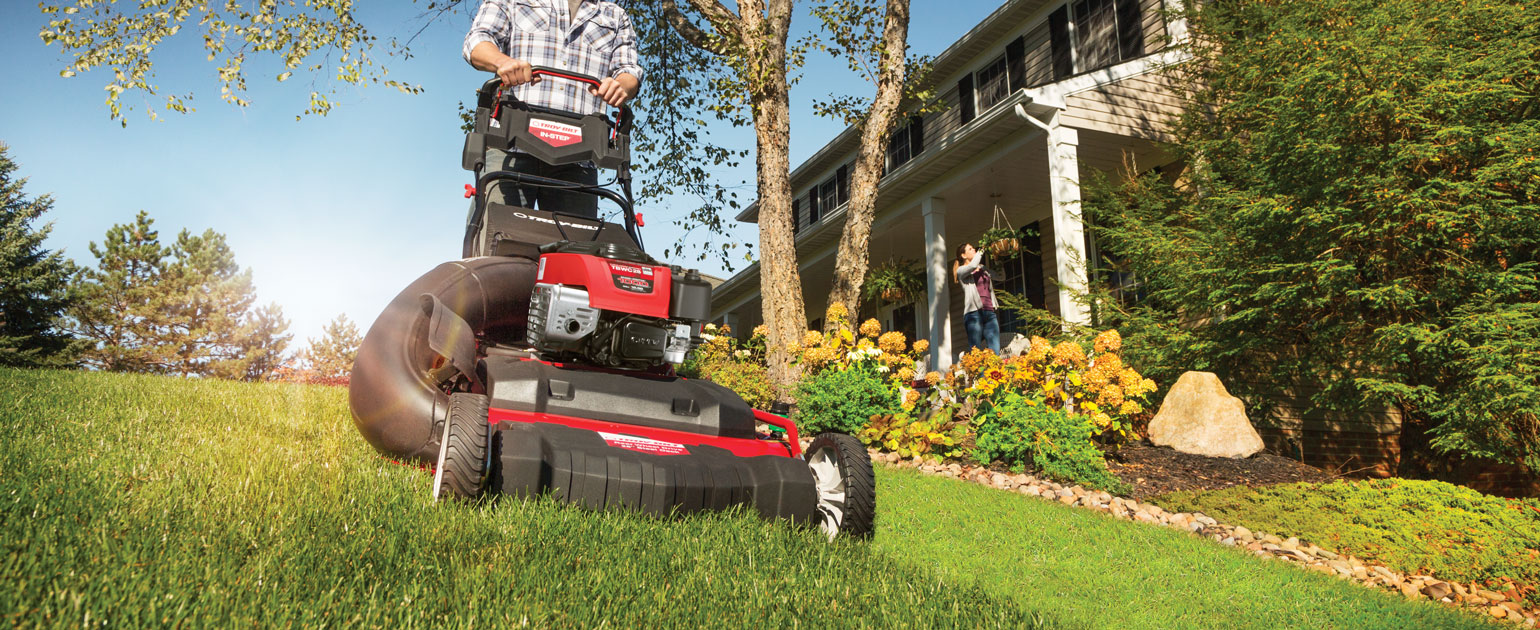 Person cutting their lawn with a Troy-Bilt Wide-Area push mower